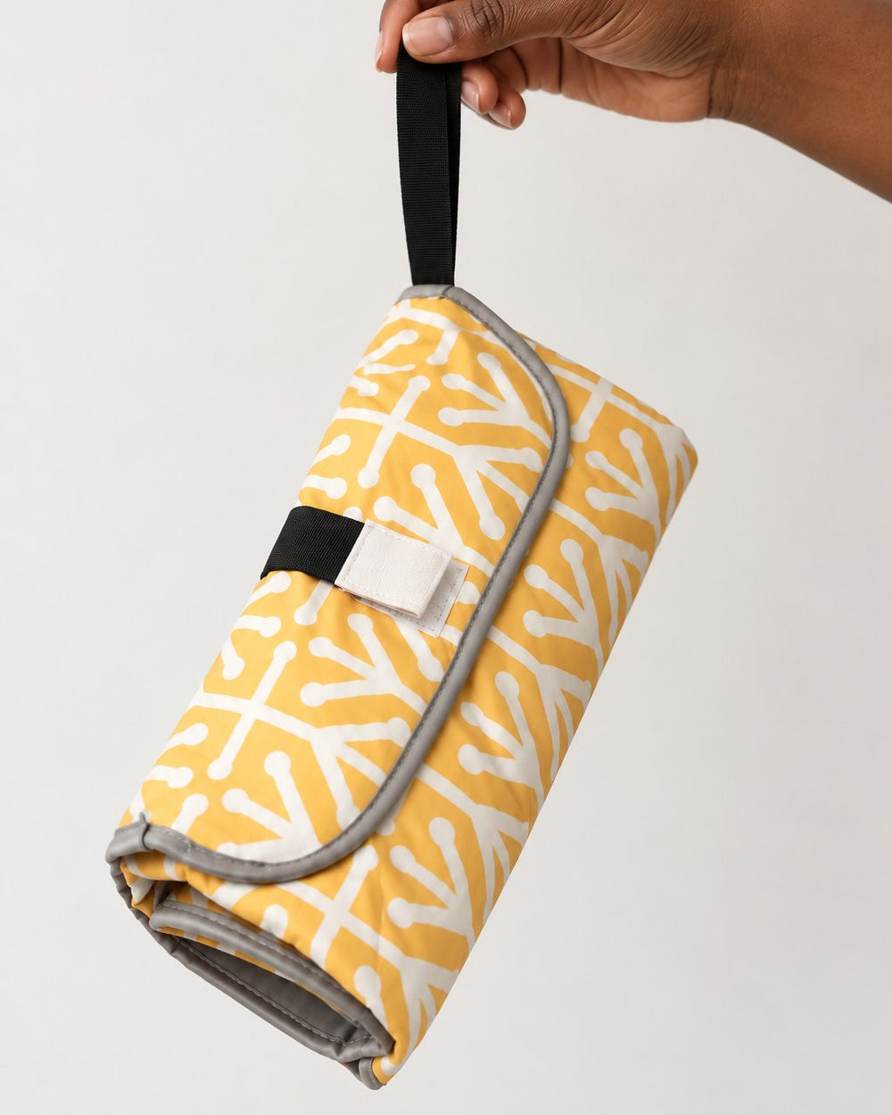 Folded clutch held in one hand, about the size of a small purse