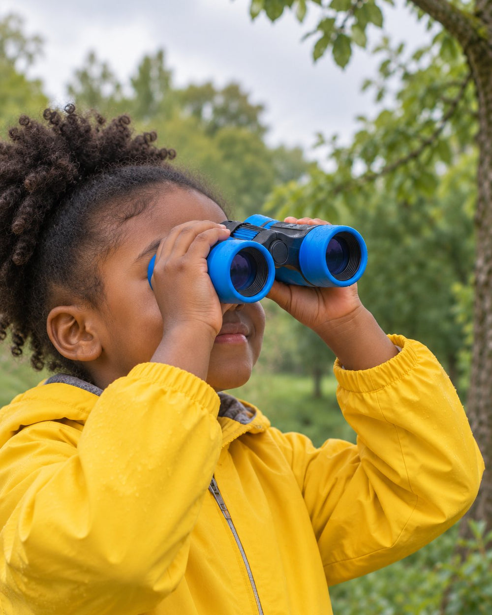 Child looking through the blue binoculars at birds in a park