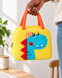 Lunch bag held in an adult hand, showing its 23 cm width