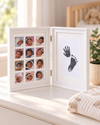 White keepsake frame standing open on a nursery dresser beside a small plant