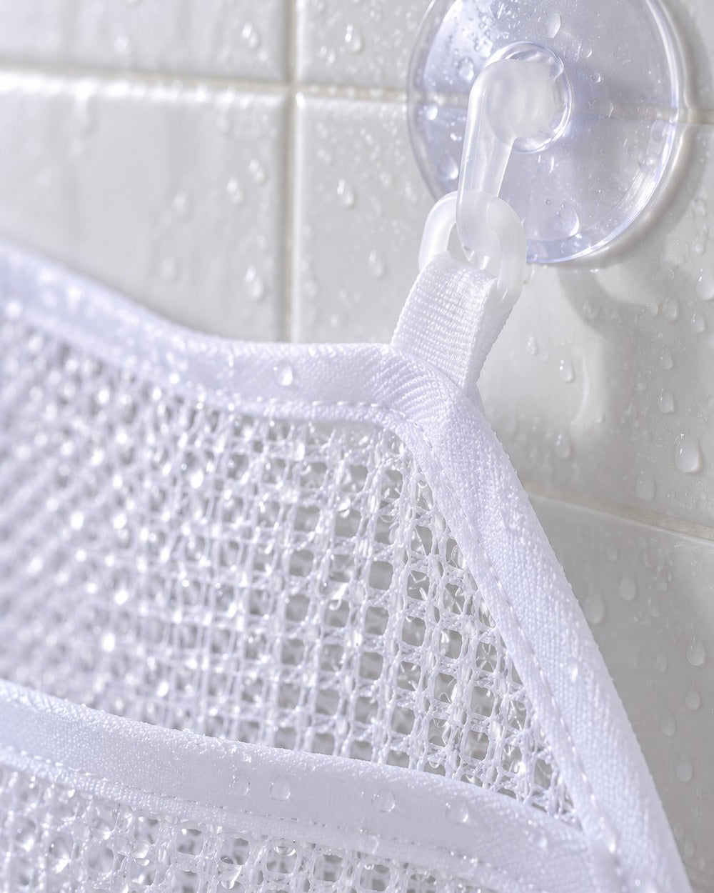Close-up of the open white mesh and a hooked suction cup on tile