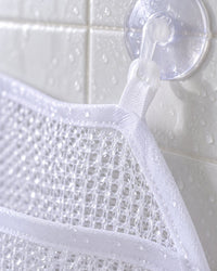 Close-up of the open white mesh and a hooked suction cup on tile