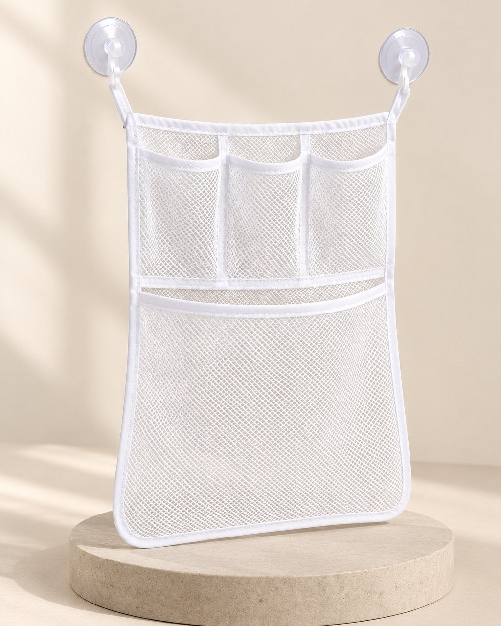 White mesh organiser with three small top pockets and a big bottom pocket, hung on two suction cups