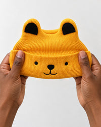 Beanie held in an adult's two hands, small and stretchy