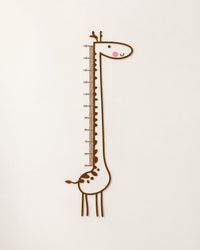 Tall brown line-drawing giraffe decal with a measuring scale up its neck, on a white wall