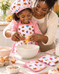 Parent and child baking together in a bright kitchen, child in the apron and cap