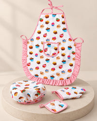 White cupcake-print kids' apron with pink frills, shown flat