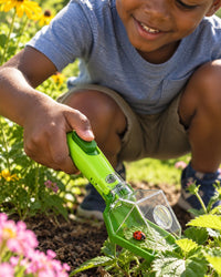 Child crouching in a garden catching a ladybird with the green bug catcher