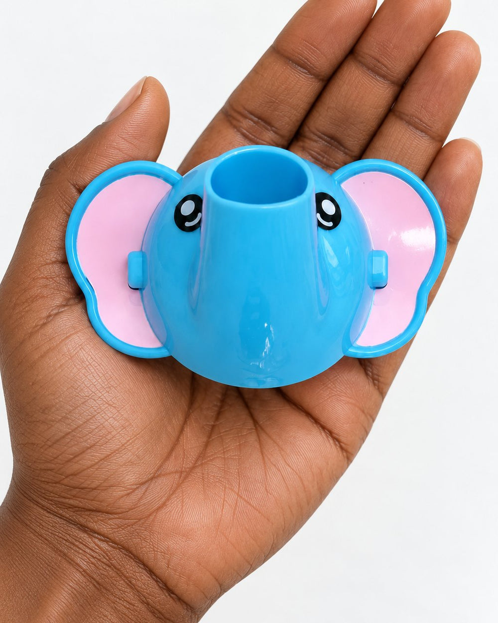 Elephant faucet extender held in an adult palm
