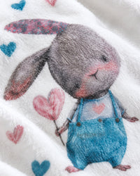 Close-up of the watercolour bunny holding a heart balloon on soft flannel
