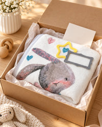 Folded bunny blanket with the felt star and frame in an open gift box