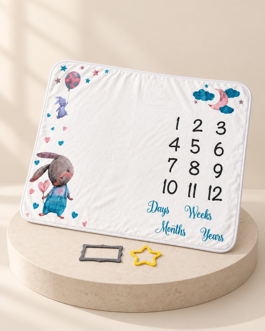 White flannel milestone blanket with a watercolour bunny, balloon, 1 to 12 grid and felt props