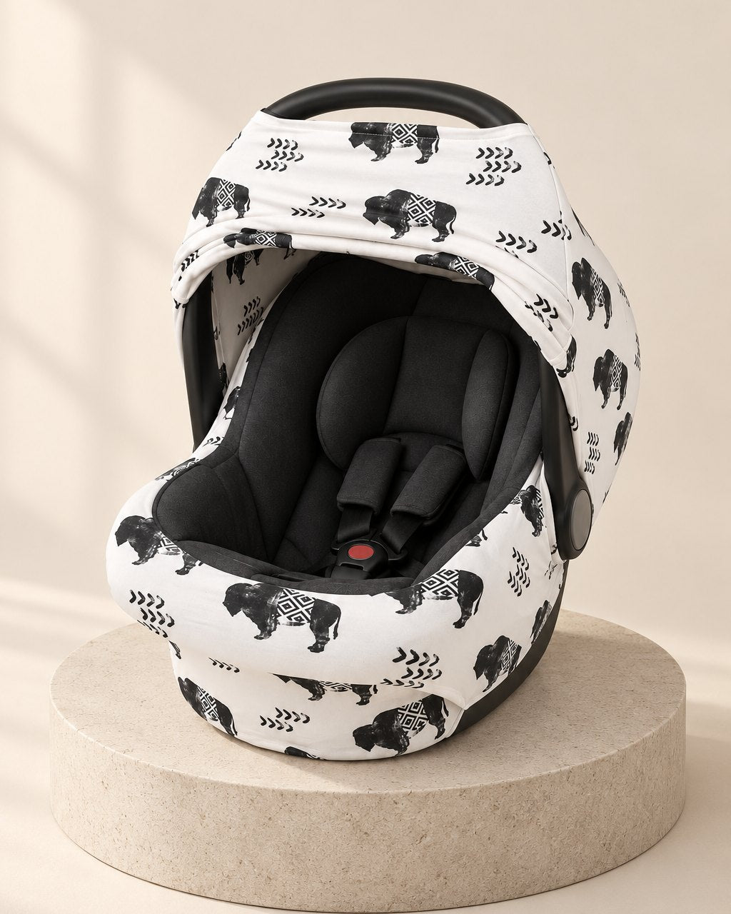 Car seat cover in a white print with black buffalo and arrows, over the canopy with the front open