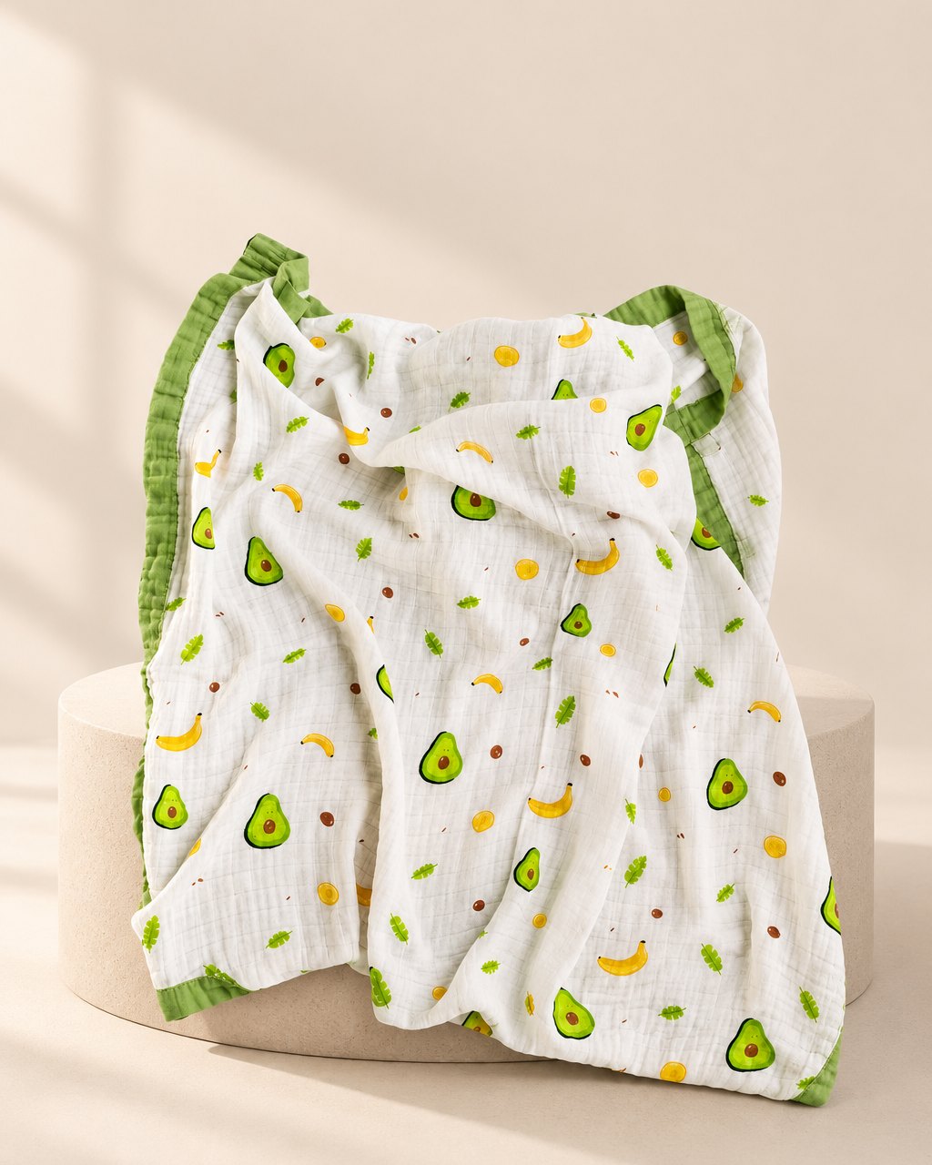 Muslin blanket with an avocado print and a green edge