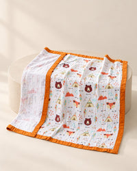 Muslin blanket with a camping bears print and an orange edge