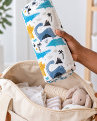 Swaddle rolled into a neat bundle and held in one hand above an open diaper bag