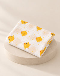 Folded white muslin swaddle printed with little yellow chicks