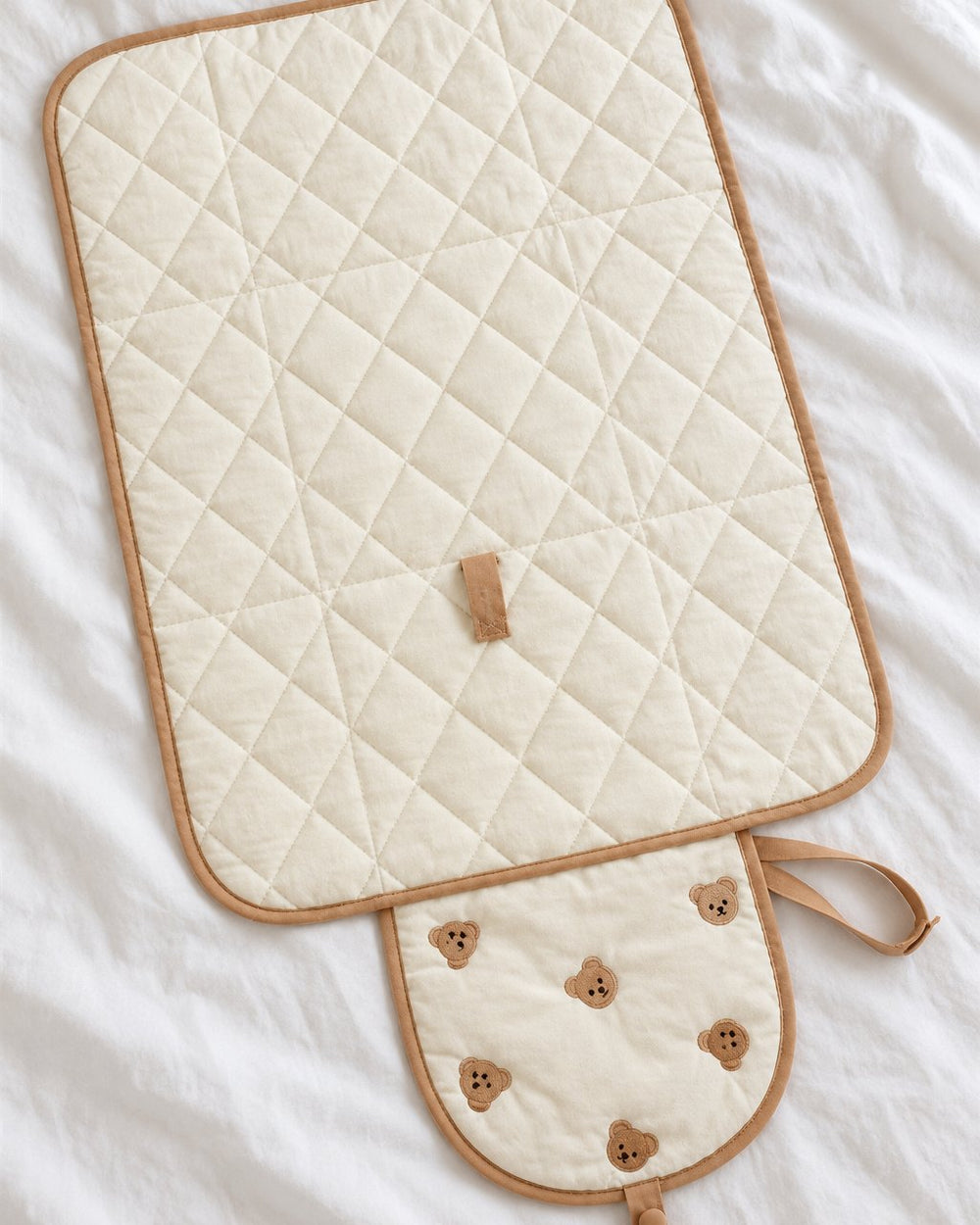 Unfolded quilted mat with diamond stitching and the bear-embroidered flap at one end