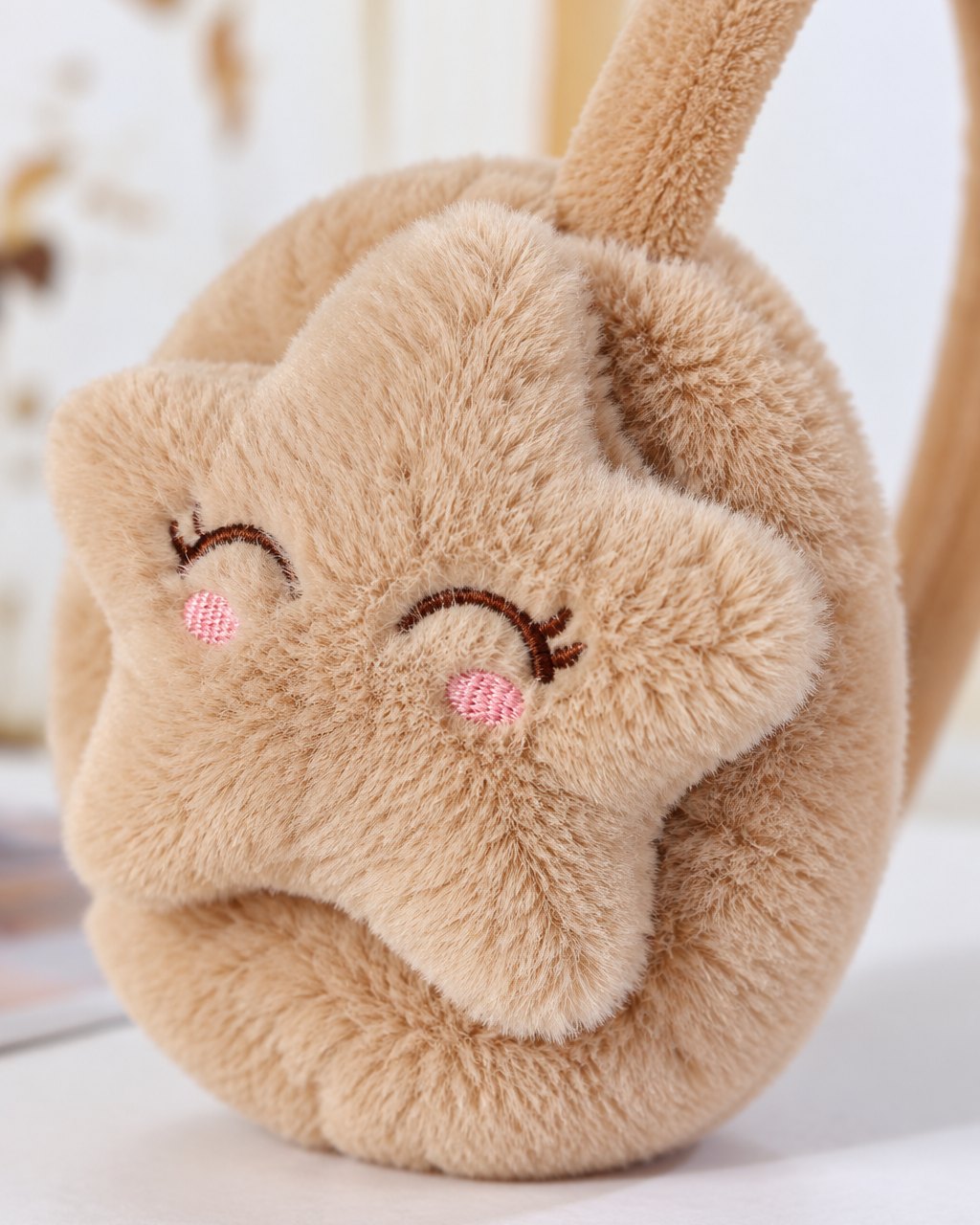 Close-up of the stitched sleepy-eyed star on the fluffy ear cup