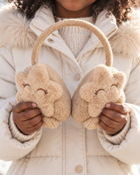 Earmuffs held in a child's hands, about as wide as the child's chest