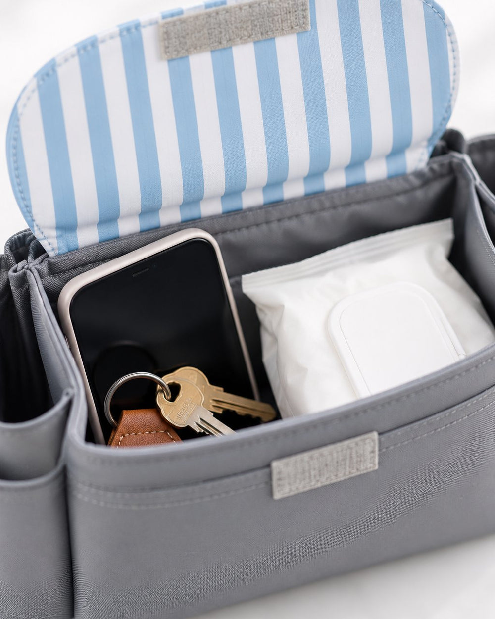 Open flap of the organizer showing a phone, keys and wipes inside