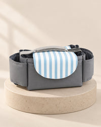 Grey stroller organizer bag with a blue-and-white striped flap and side pockets