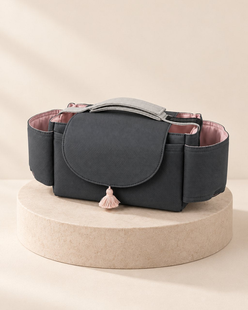 Charcoal stroller organizer with a plain flap and a small pink tassel