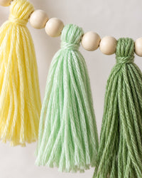 Close-up of fluffy yarn tassels between smooth wooden beads