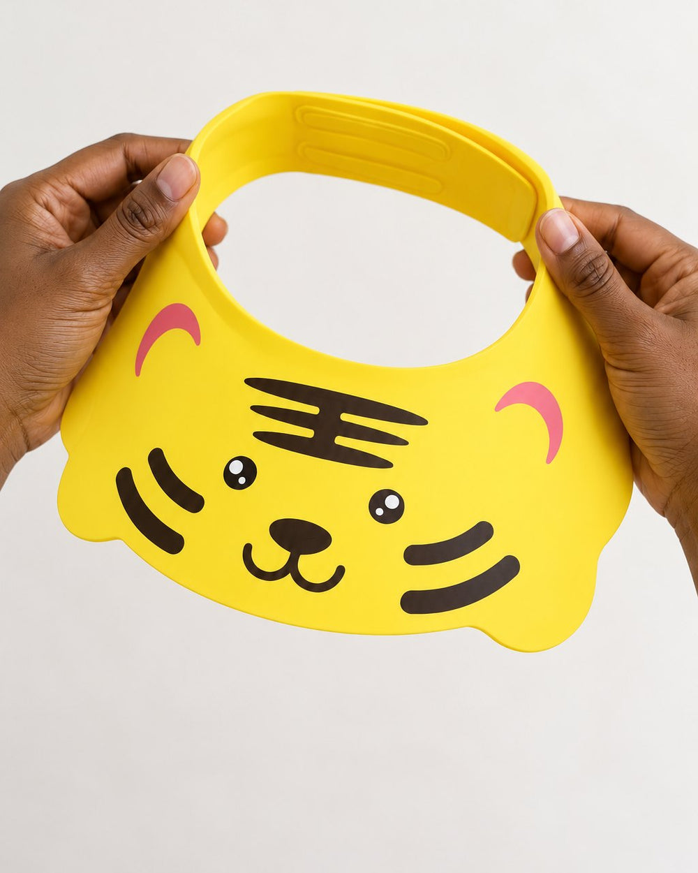 Tiger visor held open in two adult hands, about the size of a child's head