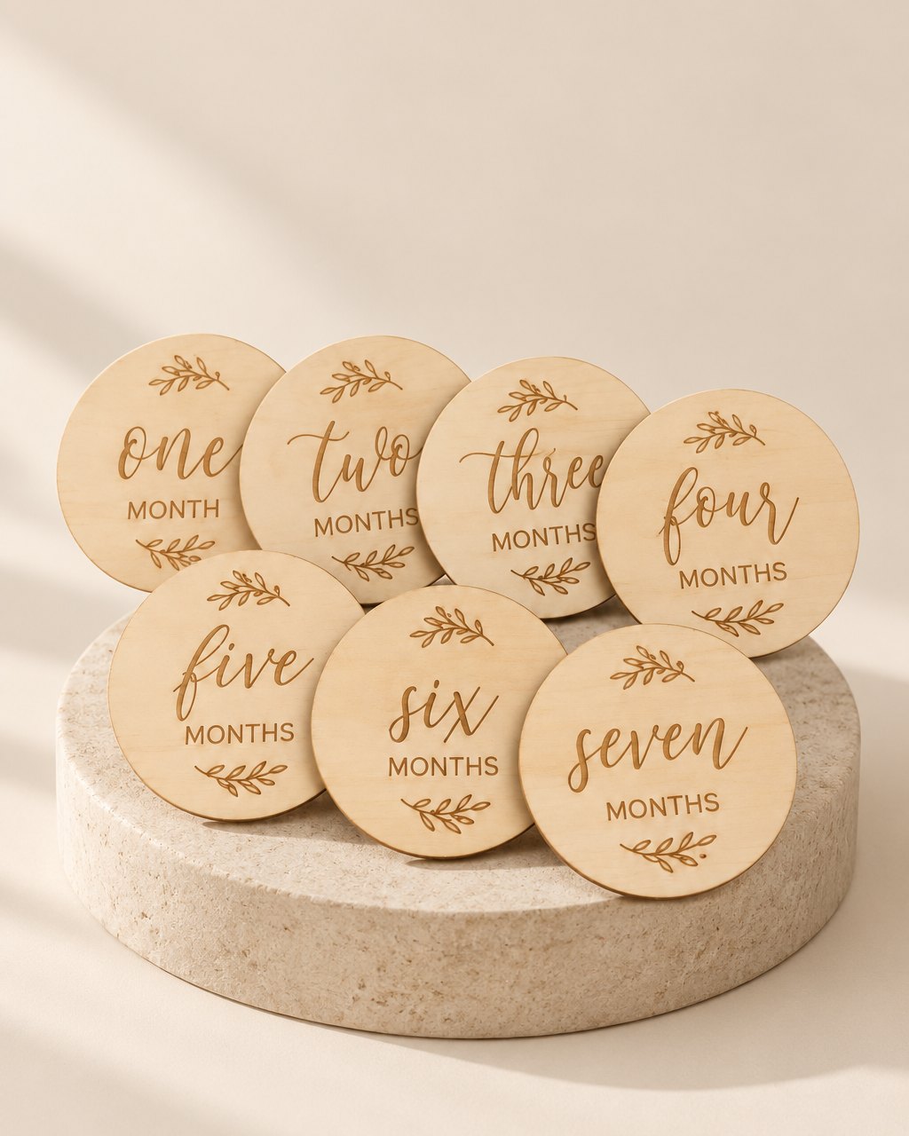 Round natural wooden discs printed with one to twelve months, hello world and welcome home
