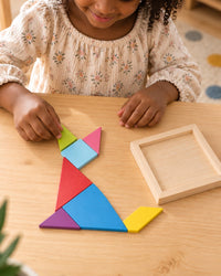 Child building a cat shape from the colourful tangram pieces