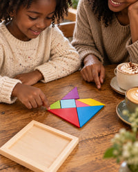 Parent and child at a café table building a boat shape with the tangram